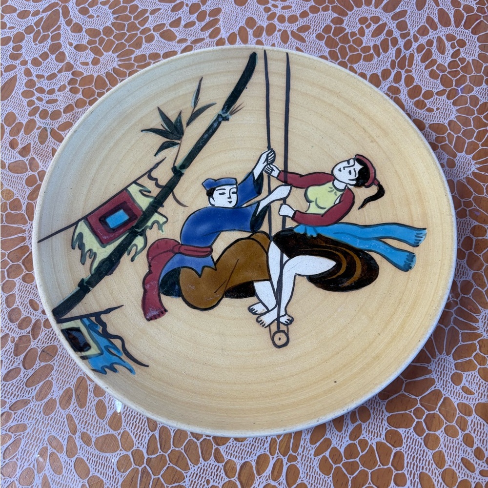 vintage, hand-painted Vietnamese ceramic plate. Young couple on a tramped.